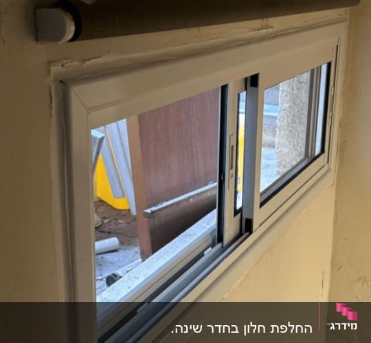 חלון אלומיניום עם מסגרת לבנה בקיר
